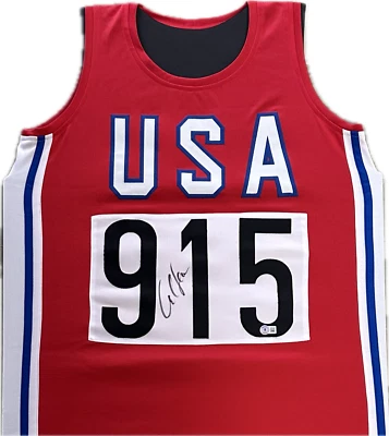 Camiseta deportiva firmada por Carl Lewis autografiada roja blanca y azul EE. UU. autenticada por Beckett Foto 1 de 2