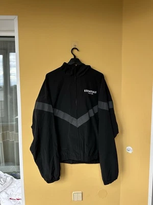 Chaqueta cortavientos Essentials Fear of God para hombre grande reflectante Chevron con capucha Foto 1 de 4