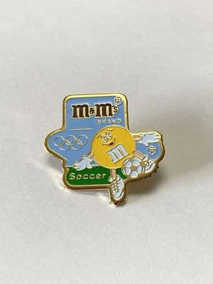 Vintage M&M Brand Barcelona Olympic Games Soccer Enamel Pin Yellow Kicking Ball - Image 1 of 4