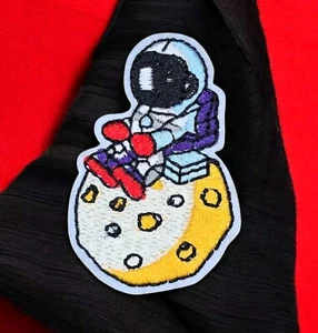 SMALL ASTRONAUT SITTING ON MOON PLANET OUTER SPACE COSMOS ART IRON ON PATCH  - Picture 1 of 6