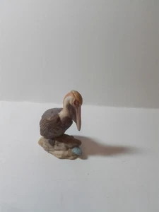 FIGURA DE PELÍCANO DE PÁJARO COSTERO DE CERÁMICA ENCARAMADA SOBRE ROCA SOBRE LA PARTE SUPERIOR DE LA CÁSCARA DE ALMEJA - Imagen 1 de 3
