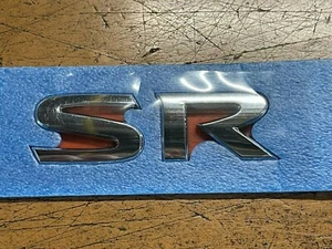 "NUEVO FABRICANTE DE EQUIPOS ORIGINALES NISSAN 2018-2021 EMBLEMA MALETERO TRASERO CROMADO ""SR" - Imagen 1 de 2