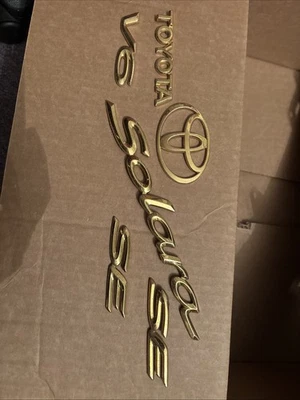 Juego de parrilla trasera emblema dorado Toyota Solara 99-03 SE V6 OEM Foto 1 de 4