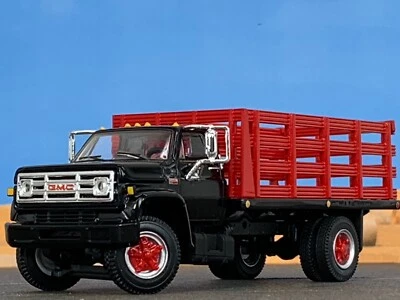 1/64 DCP BLACK/RED GMC 6500 SINGLE AXLE STAKE BED - Image 1 of 4