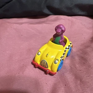 Barney der lila Dinosaurier fährt ein gelbes Taxi Spielzeugauto The Lyons Group 1993 - Bild 1 von 5