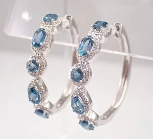 Pendientes de aro Huggie de topacio azul de corte ovalado de 2 quilates enchapados en oro blanco de 14 quilates - Imagen 1 de 8