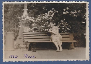 Hübsche junge Frau auf einer Bank in der Nähe von Blumen, schönes Mädchen sowjetisch Vintage Foto UdSSR - Bild 1 von 2