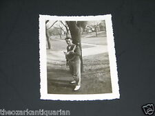 Man with tennis rackets  by tree and street in small town Independence Kansas