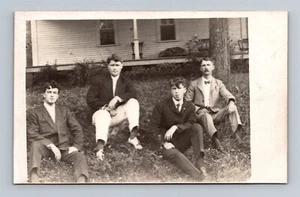 RPPC Cuatro Hombres Jóvenes en Trajes Sentados frente a una Casa Postal con Foto Real - Imagen 1 de 2