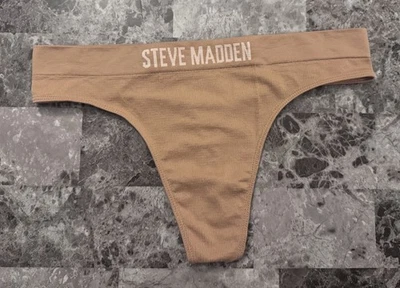 CALCINHA TANGA SEM COSTURA STEVE MADDEN BEGE GRANDE NUDE BRONZEADO COM NERVURAS LOGOTIPO BRANCO - Imagem 1 de 3