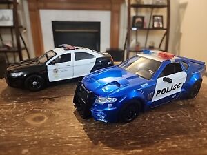 Lot of 2 1/24 Police Cars.  Transformers And Motor Max 