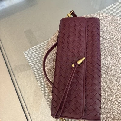 Cartera sin asas para mujer estilo color borgoña cuero tejido con herrajes dorados Foto 1 de 4
