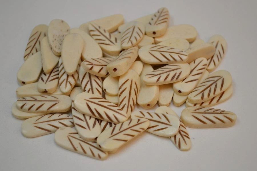 50 PCS HALF DRILLED CARVED BUFFALO BONE CHARM EAR MAKING 1 1/8" - Image 1 of 1