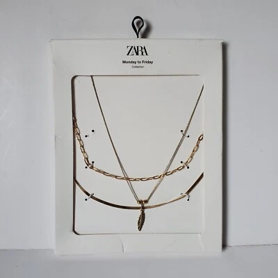 Collar de triple cadena Zara tono dorado con colgante de plumas de lunes a viernes * Foto 1 de 4