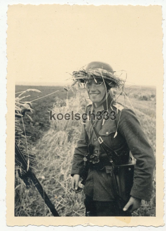 Foto Leutnant mit Helmtarnung und Fernglas am Scherenfernrohr an der Ostfront - Bild 1 von 1
