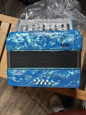 El instrumento que se muestra es un acordeón de piano IRIN de 17 teclas y 8 bajos. Foto 1 de 4