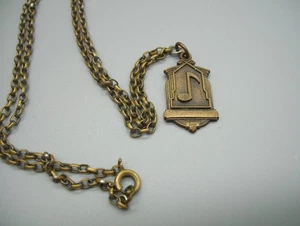 Collar vintage de 1940 para niña de secundaria con nota musical colgante de latón Herff-Jones - Imagen 1 de 7