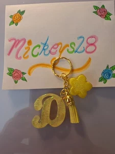 Handgefertigter UV Harz Schlüsselanhänger in gelbem Buchstabe D mit Blume und Quaste Akzenten - Bild 1 von 4