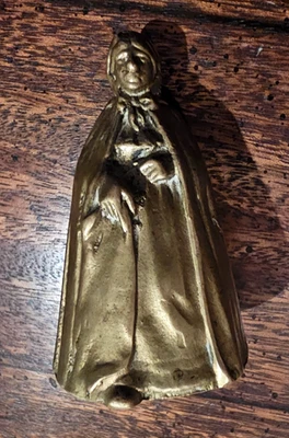 VINTAGE 2 3/4" SOLID BRASS LADY BELL WITH CAPE UNSIGNED - ONE SHOE IN FRONT - Image 1 of 3