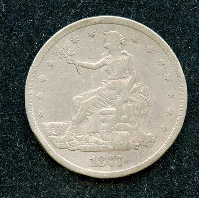 Dólar de plata 1877-EE. UU. Comercio $1 en estado bastante bueno con tope de borde y arañazos Foto 1 de 2