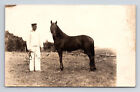 RPPC Mężczyzna w bieli z ciemnym koniem na farmie prawdziwe zdjęcie pocztówka