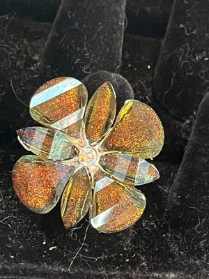 Enorme flor de plástico marrón y verde cobrizo iridiscente con banda elástica plateada Foto 1 de 4