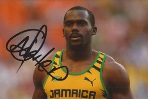 ATHLETICS: NESTA CARTER SIGNED 6x4 ACTION PHOTO+COA *JAMAICA* - Picture 1 of 1