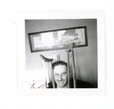 Odd composition , man with crutches by head  -  vintage snapshot photo