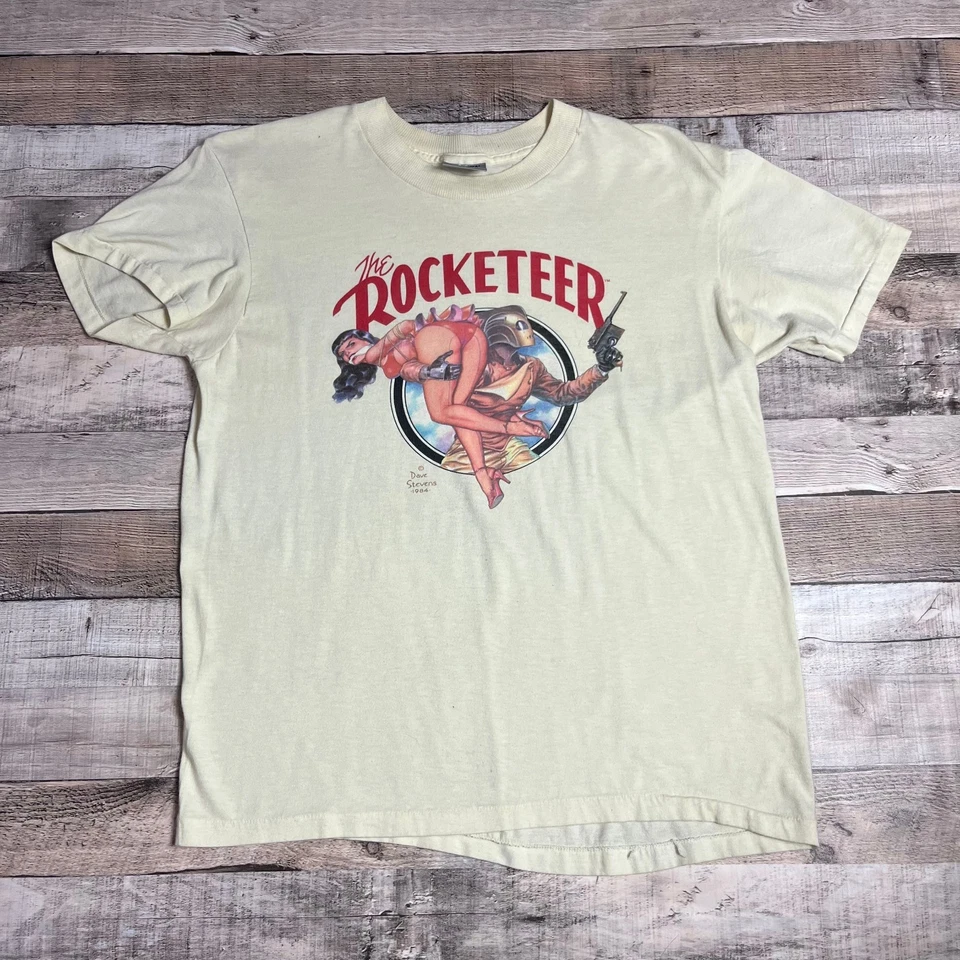 Camisa Rocketeer Grande Beige Vintage Años 80 Dave Stevens Graphitti Ciencia Ficción Fantasía Foto 1 de 4