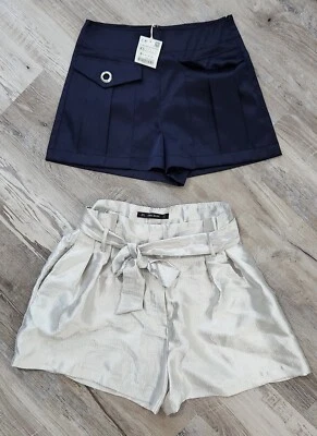 Lote de dos pares de pantalones cortos Zara azul plateado frente plano cintura alta elegantes extra pequeños Foto 1 de 4