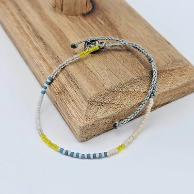 Pulsera de cuentas de semillas Pura Vida - azul Pacífico, blanco y amarillo, etiqueta P de hierro Foto 1 de 4