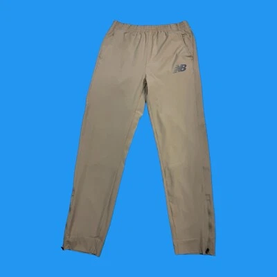 Pantalones de chándal New Balance para hombre talla pequeña forrados de malla con todo movimiento beige Foto 1 de 4