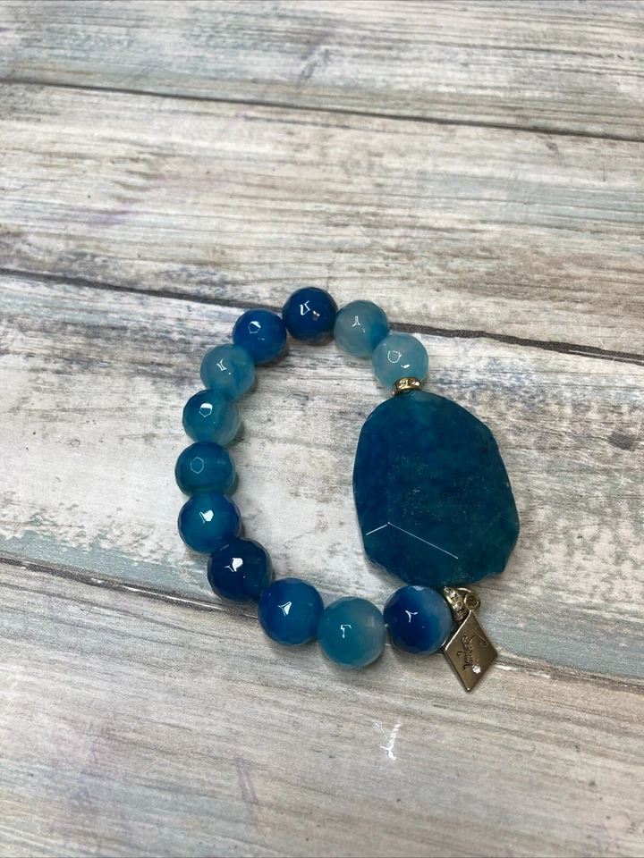 Pulsera elástica ágata azul de lentejuelas de diseñador. Diamantes de imitación con logotipo en tono dorado Foto 1 de 4