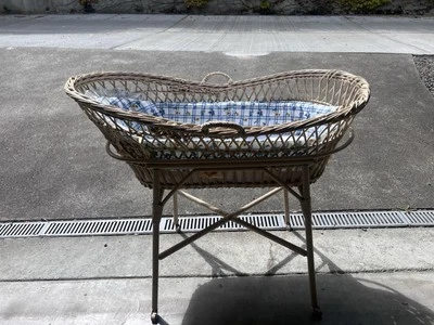 Cuna de mimbre vintage con soporte sobre ruedas incluye ropa de cama y mantas Foto 1 de 4