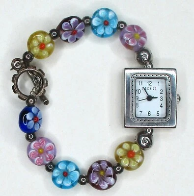 Bonito reloj de cuarzo con brazalete de flores en tono plateado esfera blanca Trendz para dama funcionando Foto 1 de 4