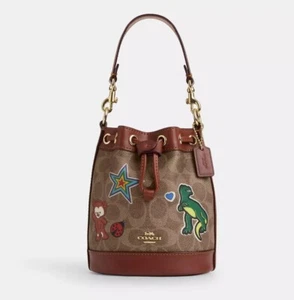 Mini borsa Coach nuova con etichette in tela firmata con stampa adesiva Rexy CW300 marrone chiaro - Foto 1 di 11