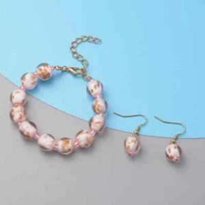 Neu ohne Etikett rosa farbiges Glas verstellbares Armband und Ohrringe in goldfarben - Bild 1 von 5