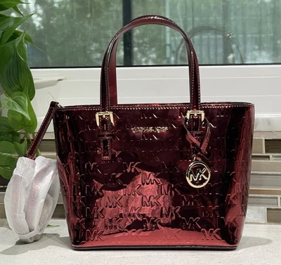 BOLSO BANDOLERA MICHAEL KORS JET TRAVEL XS CREMALLERA ROJO CEREZA EN RELIEVE METÁLICO Foto 1 de 4