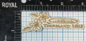 VINTAGE THOUSAND MILE OUTDOOR CLOTHING ADVERTISING GOLD WHITE 3" IRON ON PATCH - Picture 1 of 2