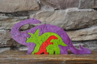 Rompecabezas de madera púrpura dinosaurio cuello largo y triceratops hecho por Amish estatuilla juguete    Foto 1 de 4