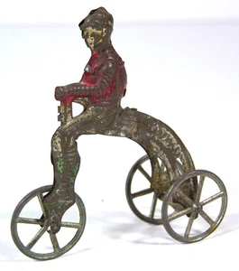 1890s TIN PENNY TOY - CICLISTA IN SELLA A UN TRICICLO DA CORSA - GIOCATTOLO CORRELATO ALLA BICICLETTA - Foto 1 di 6