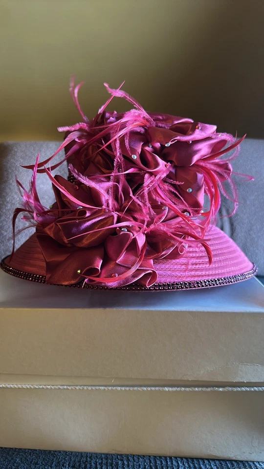 Vibrante sombrero de iglesia rosa satinado con diamantes de imitación y adornos de plumas  Foto 1 de 4