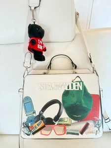 BOLSO BANDOLERA NUEVO CON ETIQUETAS STEVE MADDEN BEVELYN BLANCO CON ESTAMPADO DE CAOS CON ENCANTO DE OSO - Imagen 1 de 6