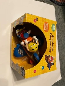 M&Ms Red and Yellow Figures ridding on a Brown Airplane Candy Dispenser 2012 - Picture 1 of 1