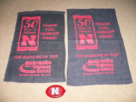 Two Nebraska Cornhuskers Towels for "50 Years of Sellouts" and Rubber Coin Purse Cover