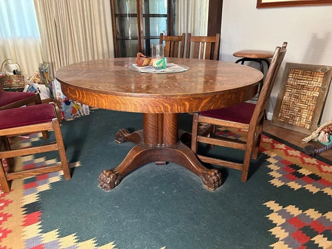 Antique round oak pedestal table. Six chairs (not original) and six 12in. leaves Cover