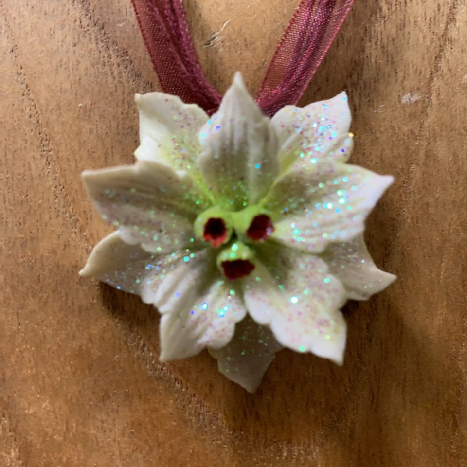 Collar/garra de cerámica blanca con brotes verdes y brillo en una cinta granate Foto 1 de 4