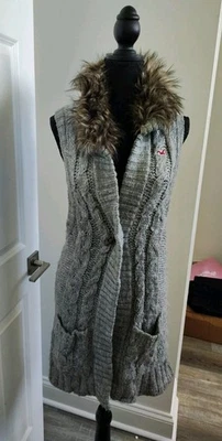 Colete longo feminino Hollister cinza com colarinho de pele sintética e um botão na frente  - Imagem 1 de 4