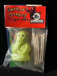Juguete vintage de tienda de centavos años 60 VERDE mono fumador cigarrillos sopla anillos de humo B - Imagen 1 de 3