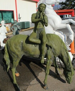 Beautiful statue of man playing flute on horse